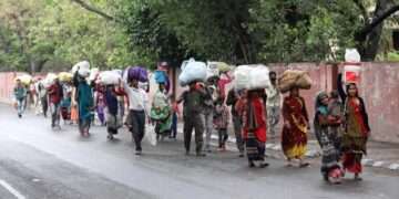 कोरोना महामारी की पहली लहर में लॉकडाउन के डर से शहरों से पलायन करते लोग